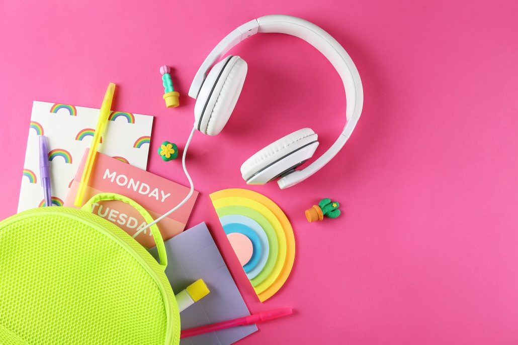 Hipster neon green textile backpack, surrounded with school supplies. Back to school concept. Lots of different stationery items on colorful background. Close up, copy space, flat lay, top view.
