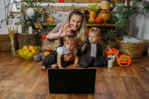 Holidays in the Time of COVID. Happy family, mother and baby celebrating Halloween via internet in new normal, Pandemic time. Online Holiday party concept Halloween Zoom