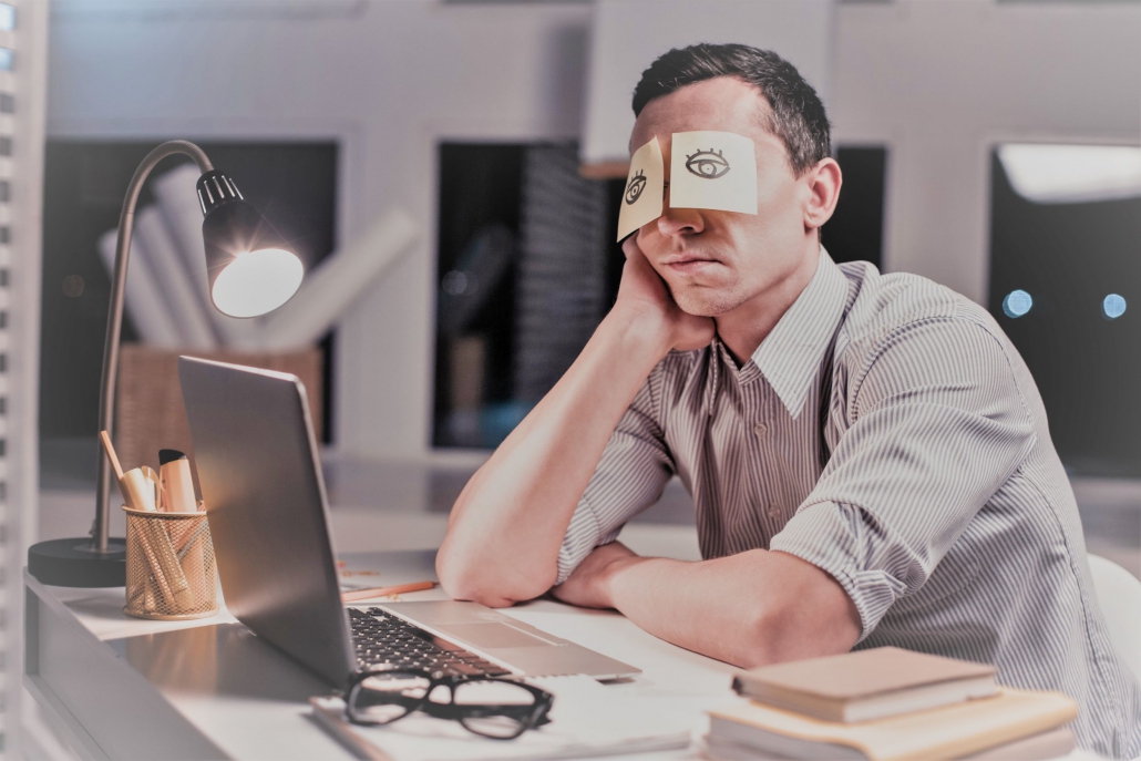 Bored office worker pretending to be asleep