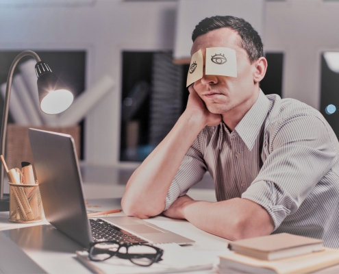 Bored office worker pretending to be asleep